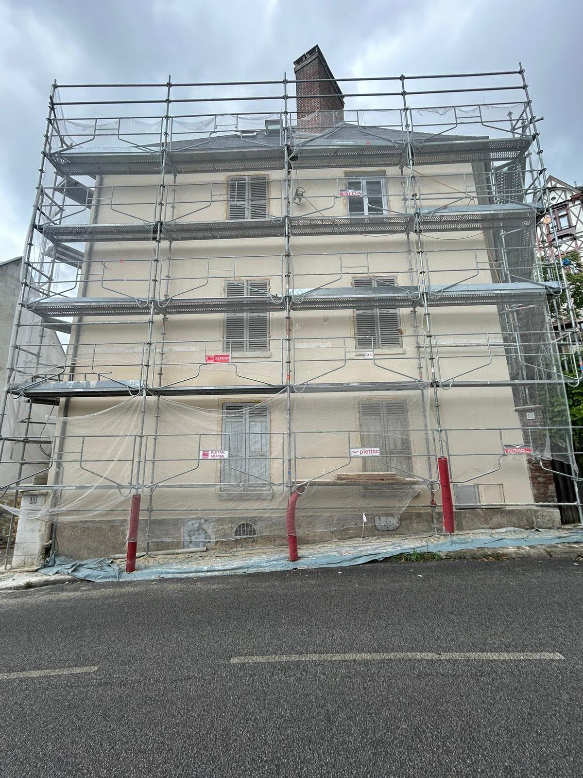 Maison de ville en rénovation : façade sous échafaudage, volets persiennés et toiture en ardoise