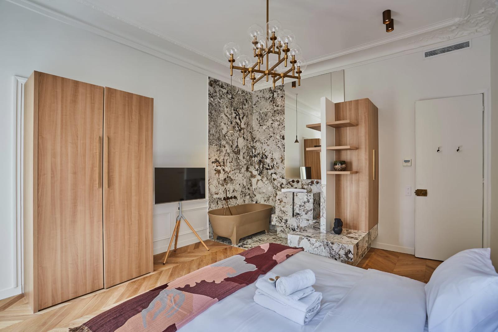 Chambre avec armoire en bois clair sur mesure et colonne d'étagères ouvertes